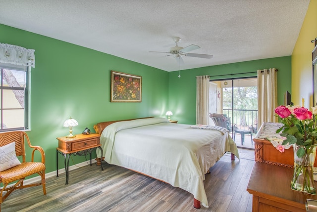 bedroom featuring access to outside, a textured ceiling, ceiling fan, and dark hardwood / wood-style flooring