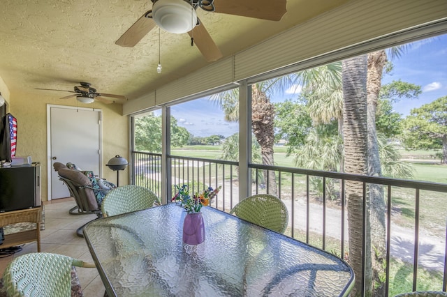 sunroom featuring ceiling fan, outdoor dining area, and plenty of natural light