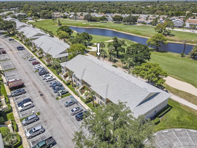 aerial perspective of suburban area with a golf course and a nearby body of water