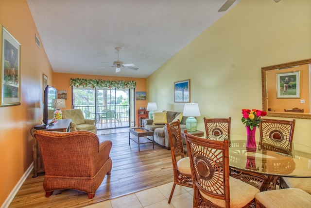 interior space featuring ceiling fan, light tile floors, and lofted ceiling