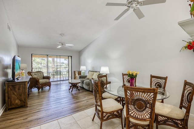 dining room featuring a ceiling fan, vaulted ceiling, and light tile patterned flooring
