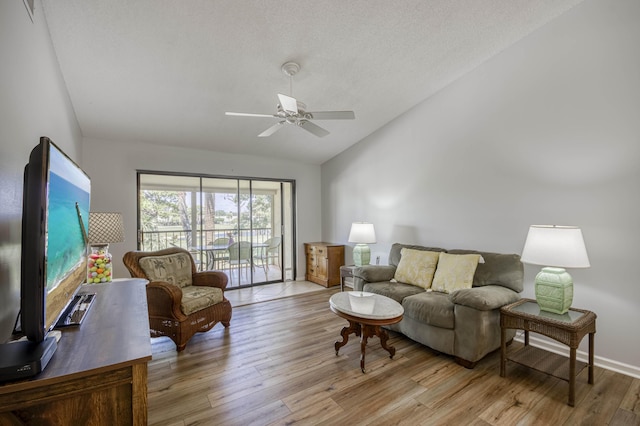 living room featuring vaulted ceiling, light wood-type flooring, and ceiling fan