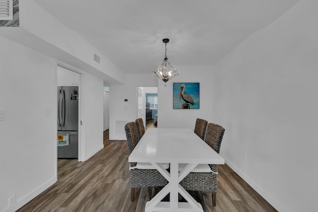 dining space featuring an inviting chandelier and dark wood-type flooring