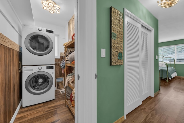 washroom featuring stacked washing maching and dryer and dark hardwood / wood-style floors