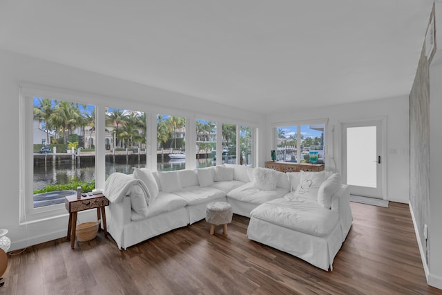 living room with dark hardwood / wood-style floors and a water view