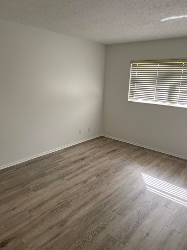 unfurnished room featuring a textured ceiling and dark wood-type flooring