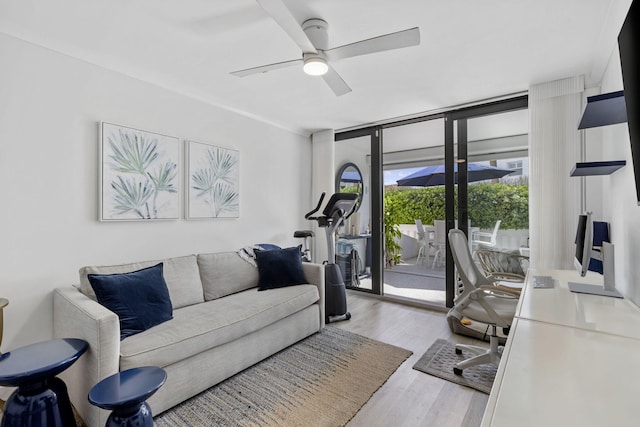 living room featuring light wood-type flooring, floor to ceiling windows, and ceiling fan