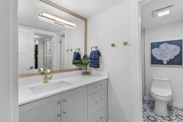 bathroom featuring tile patterned flooring, vanity, and toilet