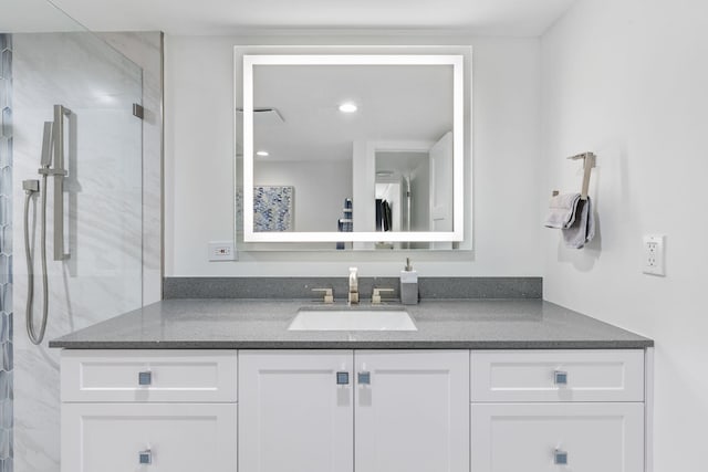 bathroom with vanity and a shower with door