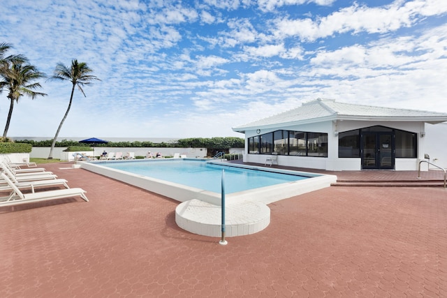 view of pool with a sunroom and a patio