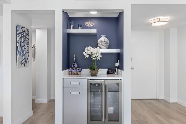 bar featuring wine cooler and light hardwood / wood-style floors