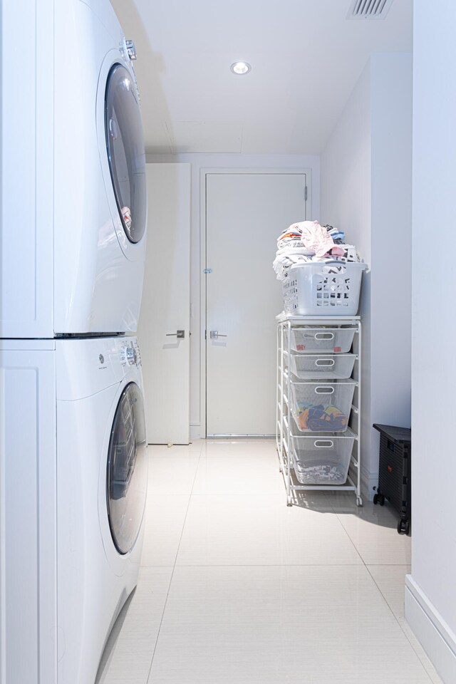 washroom featuring stacked washer / dryer and light tile patterned flooring