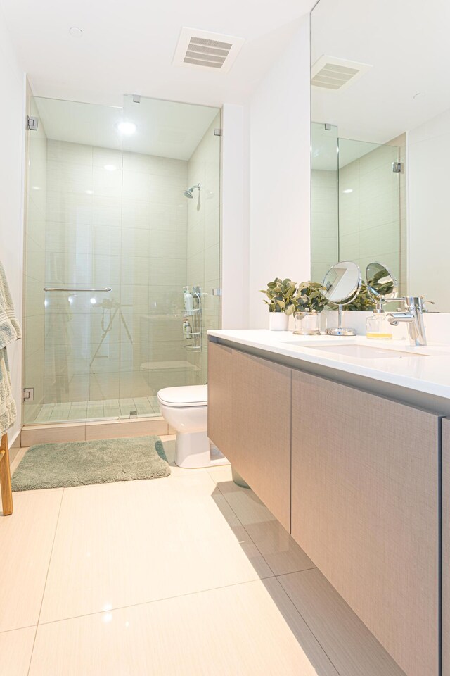 bathroom featuring an enclosed shower, tile patterned flooring, toilet, and vanity