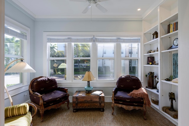 living area with ceiling fan and crown molding