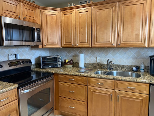 kitchen with sink, stainless steel appliances, tasteful backsplash, and stone countertops