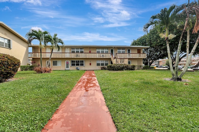 back of house with a balcony and a lawn