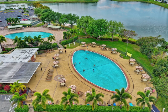 view of pool featuring a yard, a patio area, and a water view