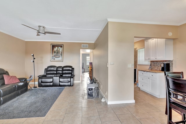 living room with light tile flooring, ornamental molding, and ceiling fan