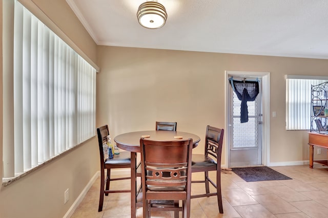 tiled dining area featuring crown molding