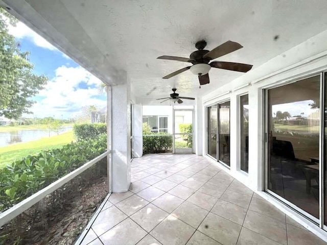 exterior space featuring ceiling fan and a water view