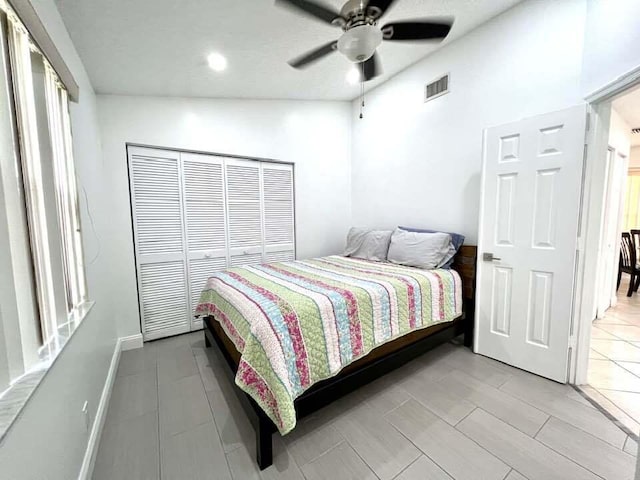 bedroom featuring a closet, light tile flooring, ceiling fan, and vaulted ceiling