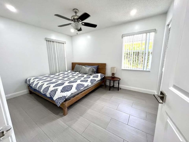 tiled bedroom featuring a closet, ceiling fan, and a textured ceiling