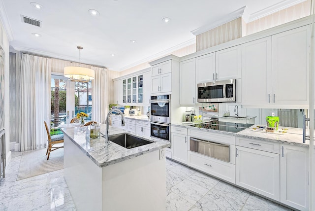 kitchen with ornamental molding, white cabinets, appliances with stainless steel finishes, and sink