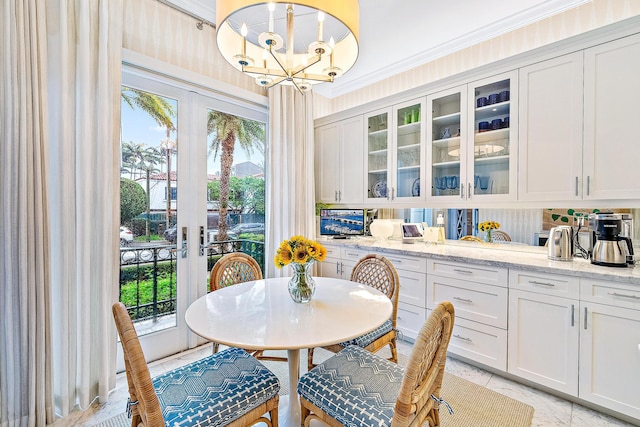 tiled dining area featuring a notable chandelier, french doors, and ornamental molding