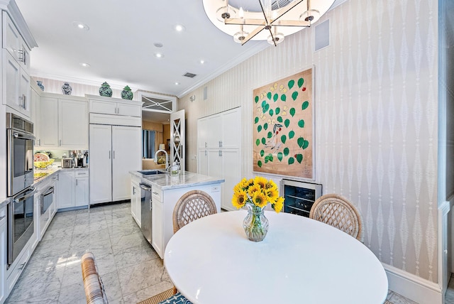 kitchen featuring appliances with stainless steel finishes, light tile floors, a center island with sink, light stone counters, and crown molding