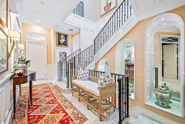 tiled entryway featuring a high ceiling and crown molding