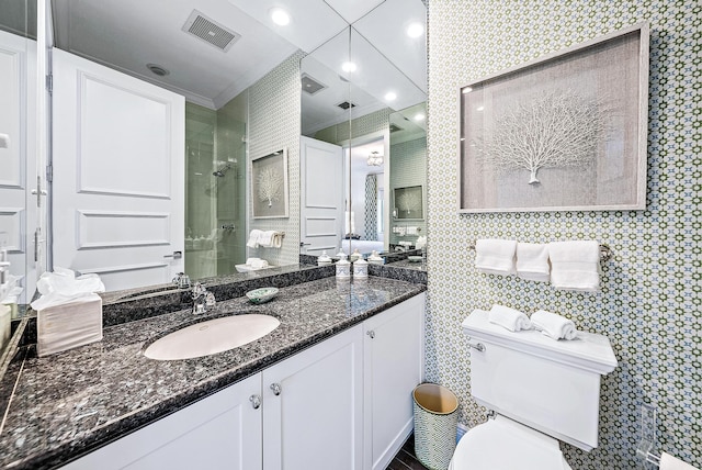 bathroom featuring toilet, large vanity, and a shower