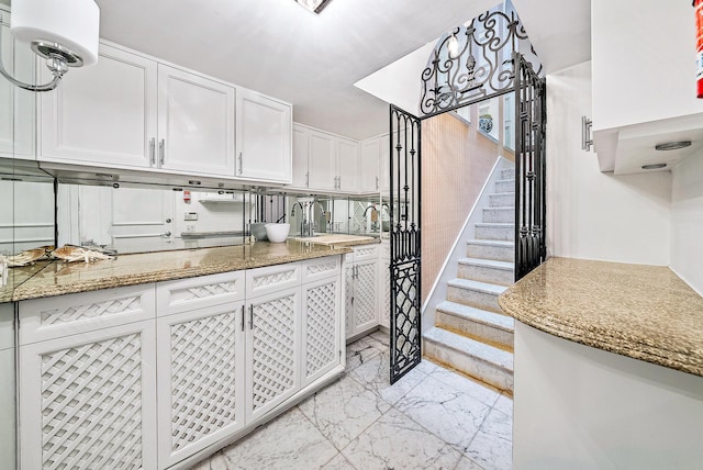 kitchen featuring light tile floors, white cabinetry, and light stone counters