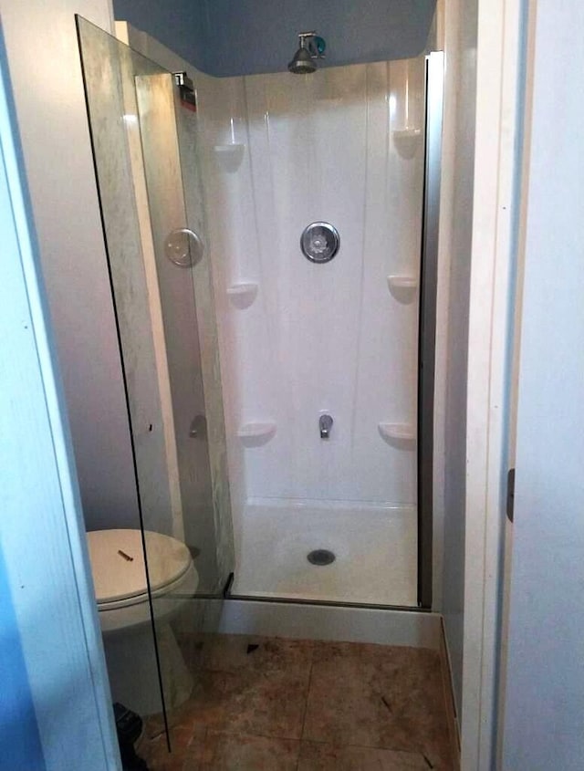 bathroom with walk in shower, tile floors, and toilet