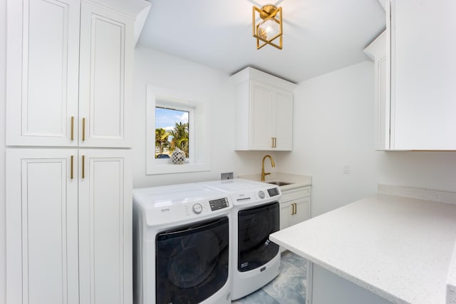 washroom featuring sink, cabinets, and washing machine and clothes dryer