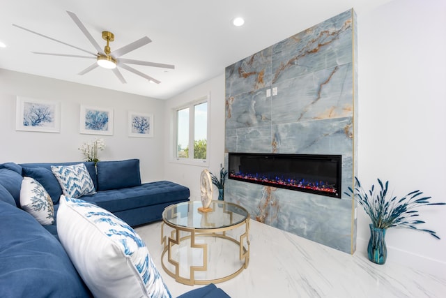 living room featuring ceiling fan and a high end fireplace