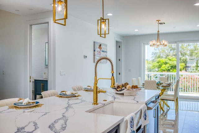 kitchen with sink, decorative light fixtures, and light stone counters