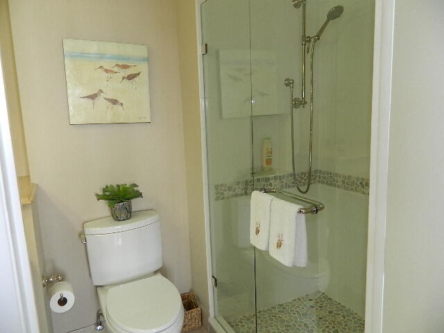 bathroom featuring toilet and an enclosed shower