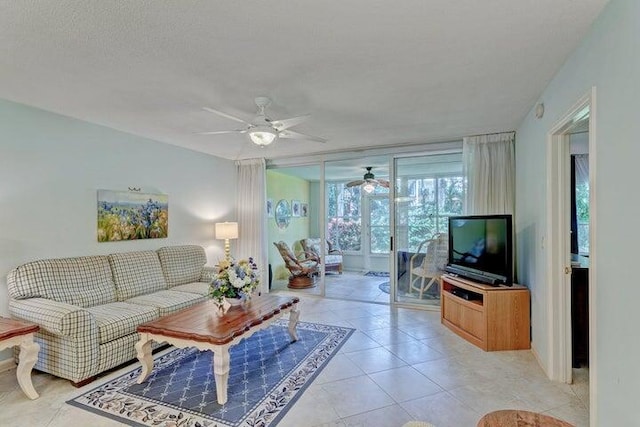 living room with ceiling fan, light tile patterned floors, and a textured ceiling