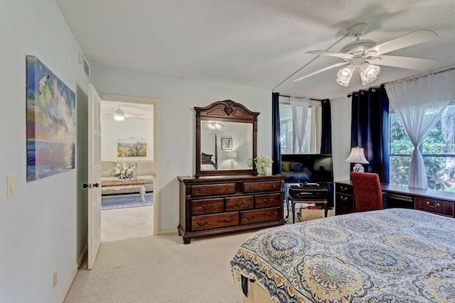 carpeted bedroom featuring ceiling fan and a textured ceiling