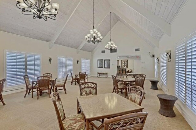 dining room with a notable chandelier, high vaulted ceiling, beamed ceiling, and light carpet