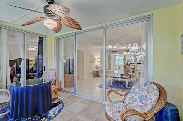 sunroom featuring ceiling fan with notable chandelier