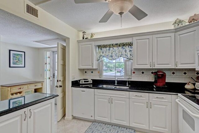 kitchen with sink, white appliances, white cabinetry, and light tile patterned floors