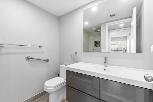 bathroom featuring toilet, vanity, and hardwood / wood-style floors