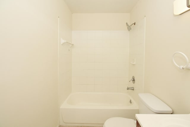 full bathroom featuring tiled shower / bath combo, toilet, and vanity