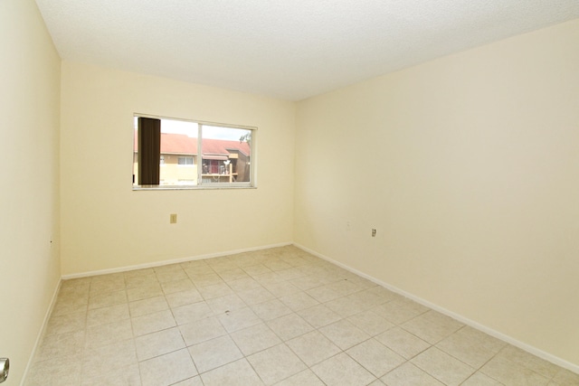 tiled spare room featuring a textured ceiling