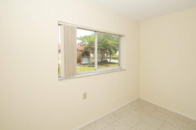 tiled spare room featuring a textured ceiling