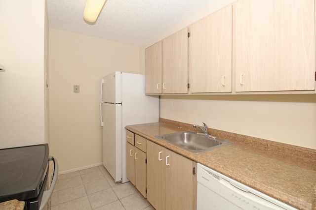 kitchen featuring white appliances, sink, light tile floors, light brown cabinets, and a textured ceiling