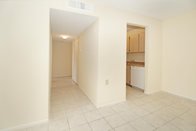 tiled spare room featuring a textured ceiling and sink