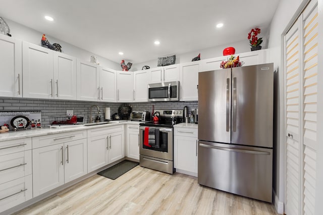 kitchen with sink, white cabinets, and appliances with stainless steel finishes