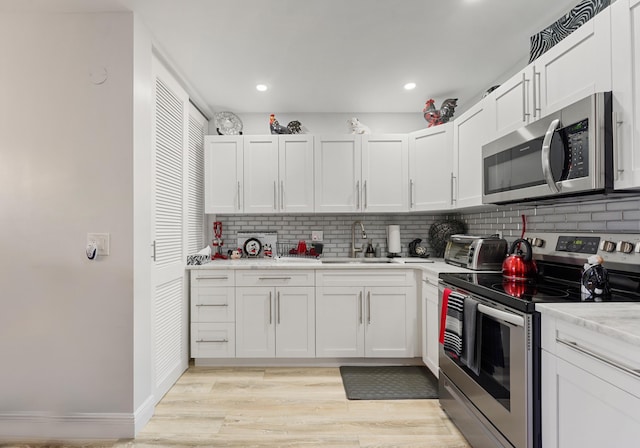 kitchen with sink, white cabinets, and stainless steel appliances